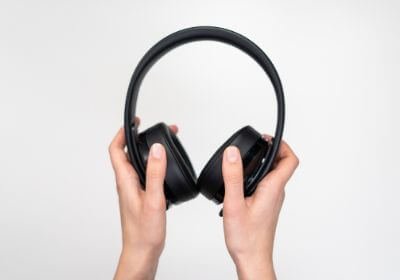 Hand holding black headphones